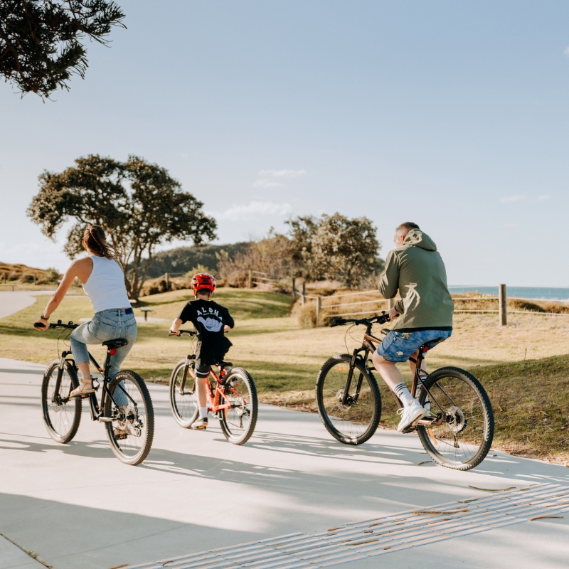 family riding bikes in mt maunganui
